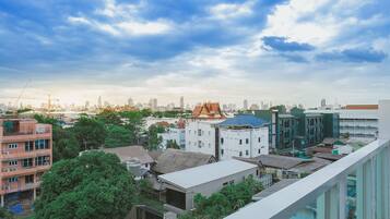 A cityscape with various buildings, including residential and commercial structures, under a partly cloudy sky.