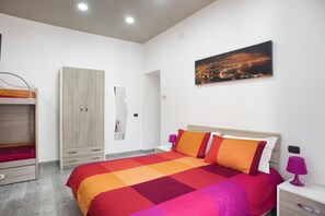 A bedroom with a bed, nightstands, a wardrobe, and a cityscape painting. - La Casa di Luna BnB (Naples)