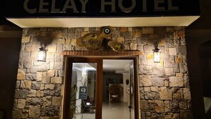 La entrada del Hotel Celay, con fachada de piedra y un letrero de recepción sobre la puerta.
