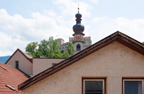 A building with a prominent tower and a red-tiled roof. - Hotel Goldene Rose (Brunico)