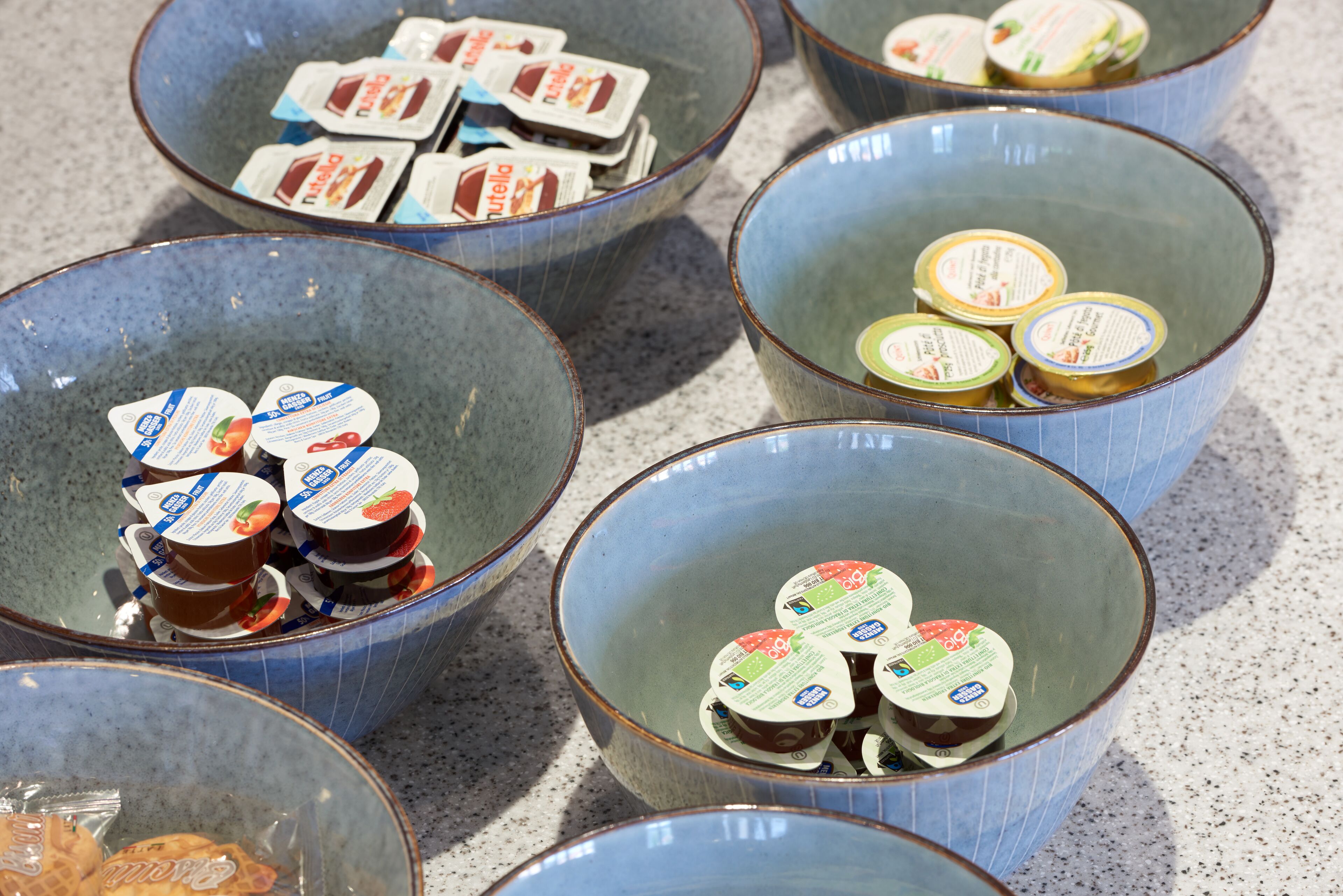Several ceramic bowls containing packaged food items.