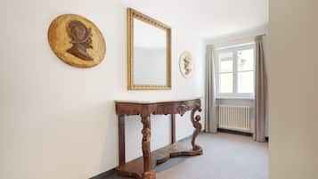 Ein Flur mit einem Holztischchen, einem großen Spiegel und zwei Wanddekorationen.