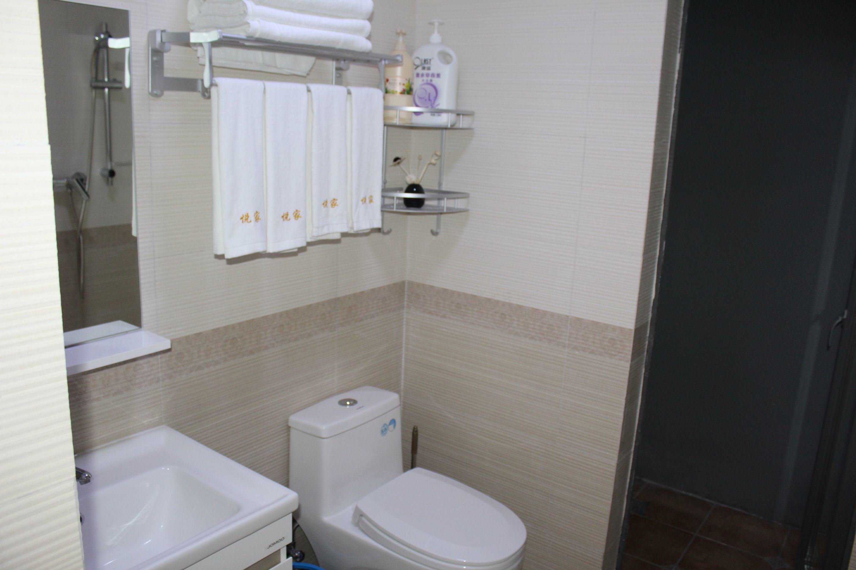 A bathroom with a toilet, sink, and towel rack.