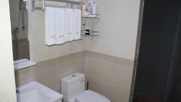 A bathroom with a toilet, sink, and towel rack.