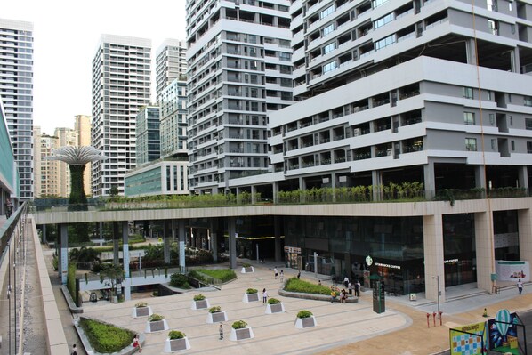 A modern urban plaza with high-rise buildings, a Starbucks Coffee, and a unique spherical structure.