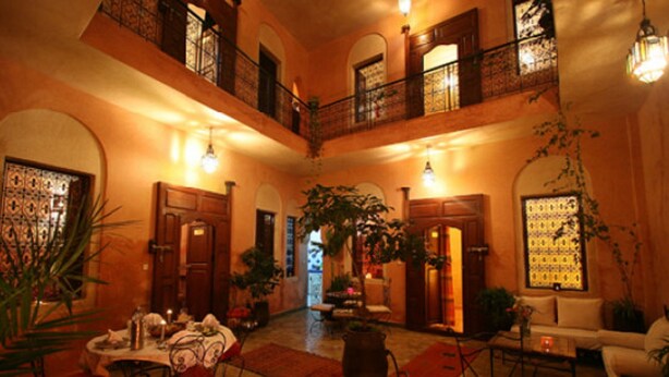 A spacious courtyard with a dining area, multiple seating arrangements, and a balcony. - Riad Todra (Marrakech)