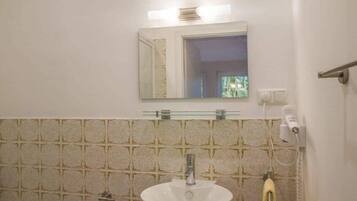 A bathroom with a white sink, a mirror, and a towel rack.