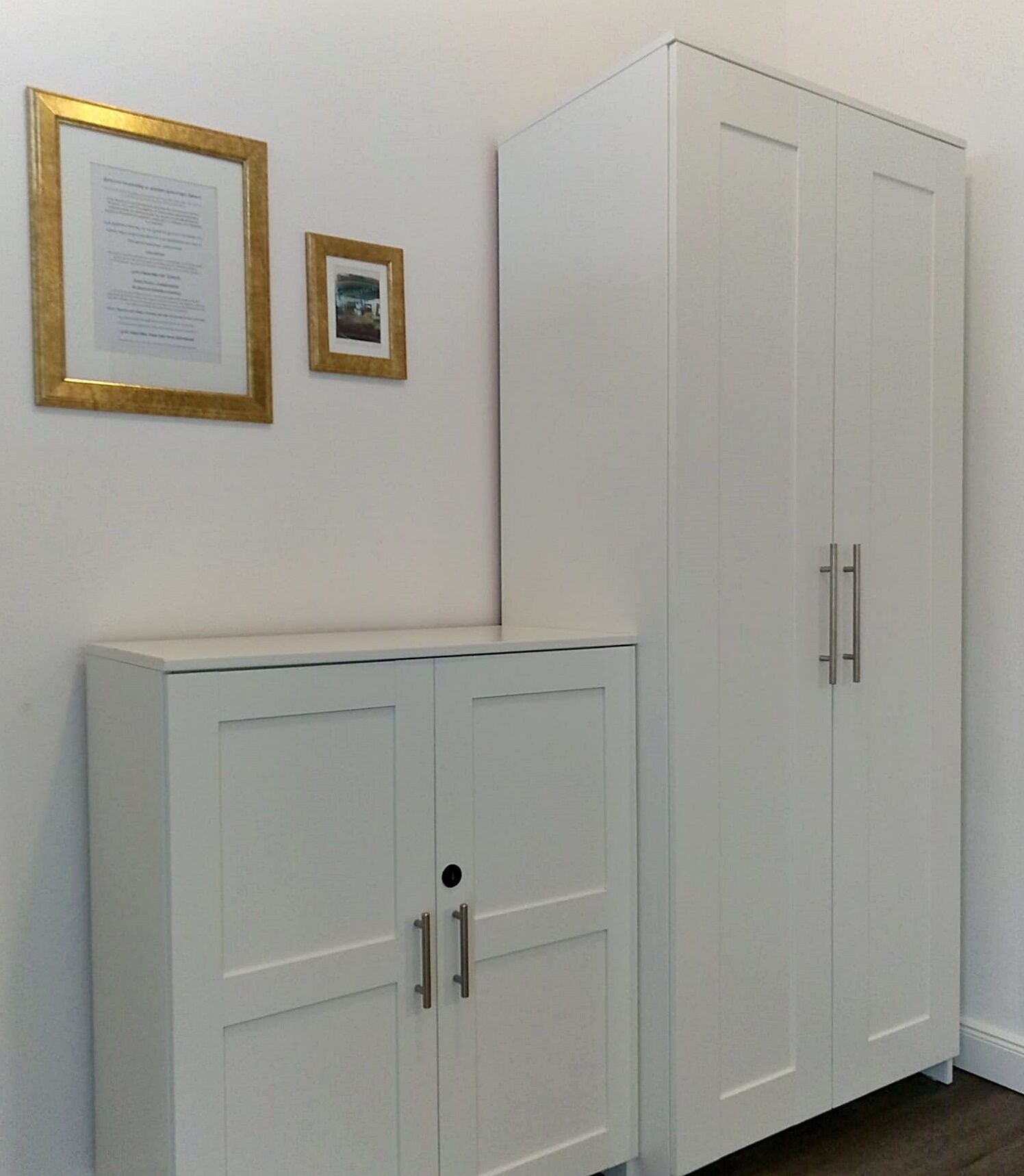 A white wardrobe with two doors and a smaller cabinet with one door.