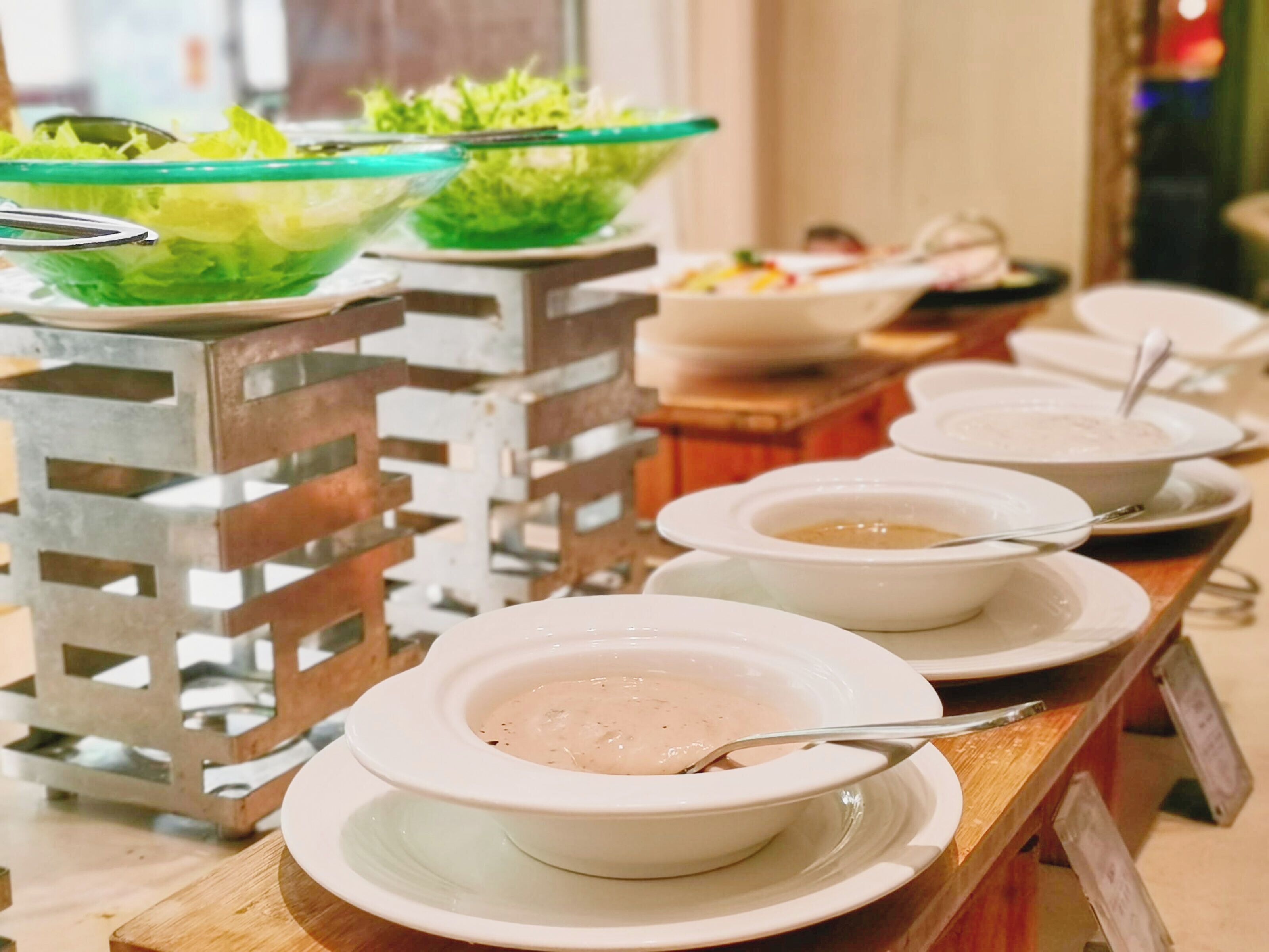 Uma mesa de madeira com diversos pratos e tigelas em estilo buffet.