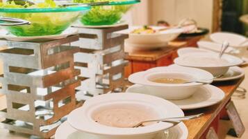 Uma mesa de madeira com diversos pratos e tigelas em estilo buffet.