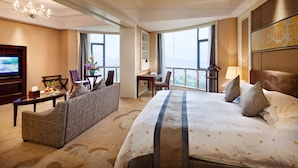 A hotel room with a large bed, a sofa, a desk, and a TV. - Goodview Hotel Sangem Zhangmutou (Dongguan)