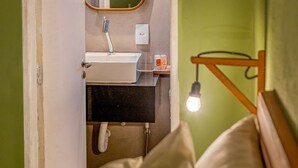 Un baño con un lavabo blanco, un espejo y una toalla colgada en la pared.