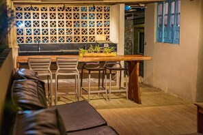 Uma cozinha aconchegante com balcão de madeira, banquetas e um espaço para sentar.