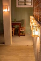 Un pasillo con piso de madera y una pared con una serie de luces.