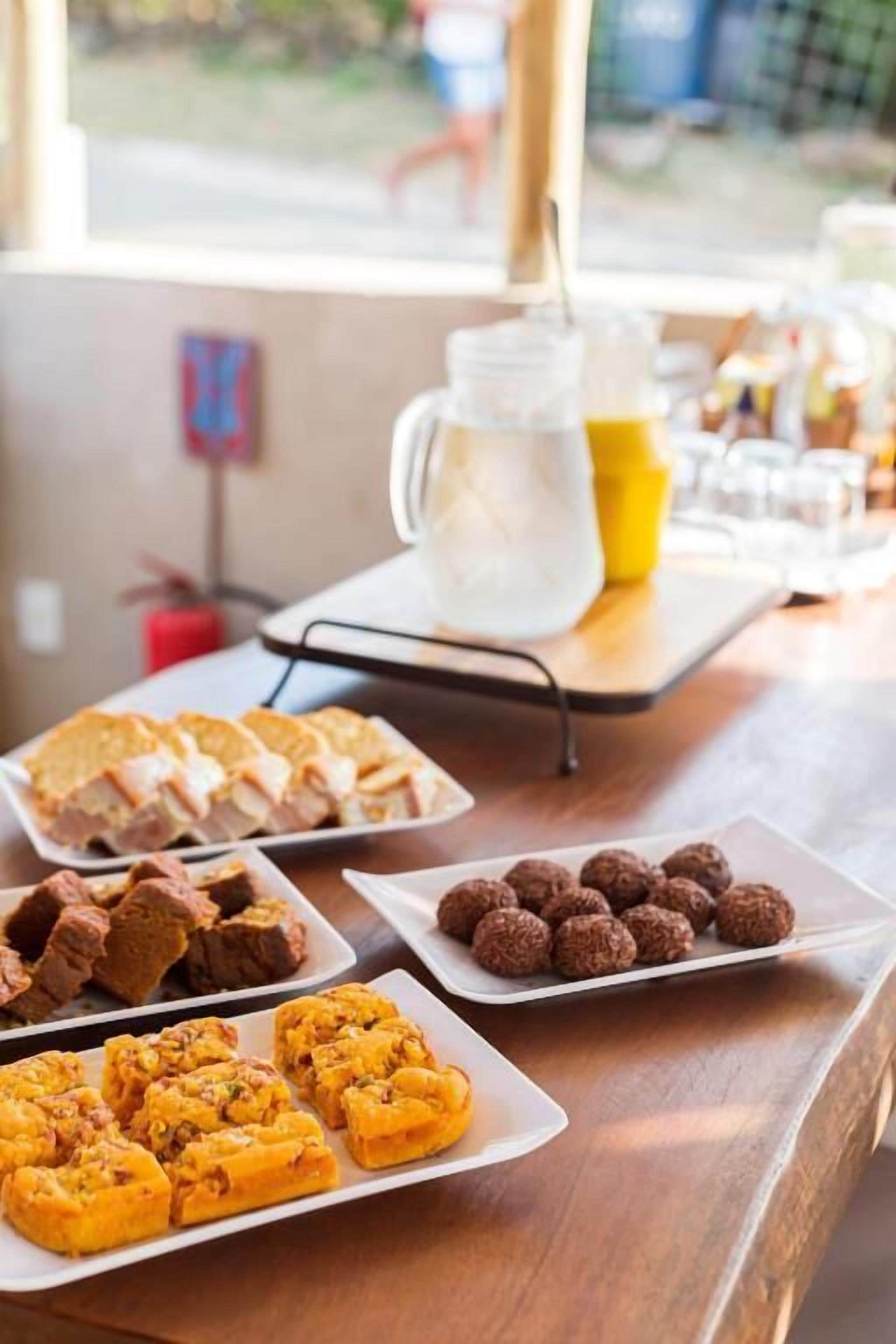 Une table avec divers aliments et une carafe contenant une boisson jaune.