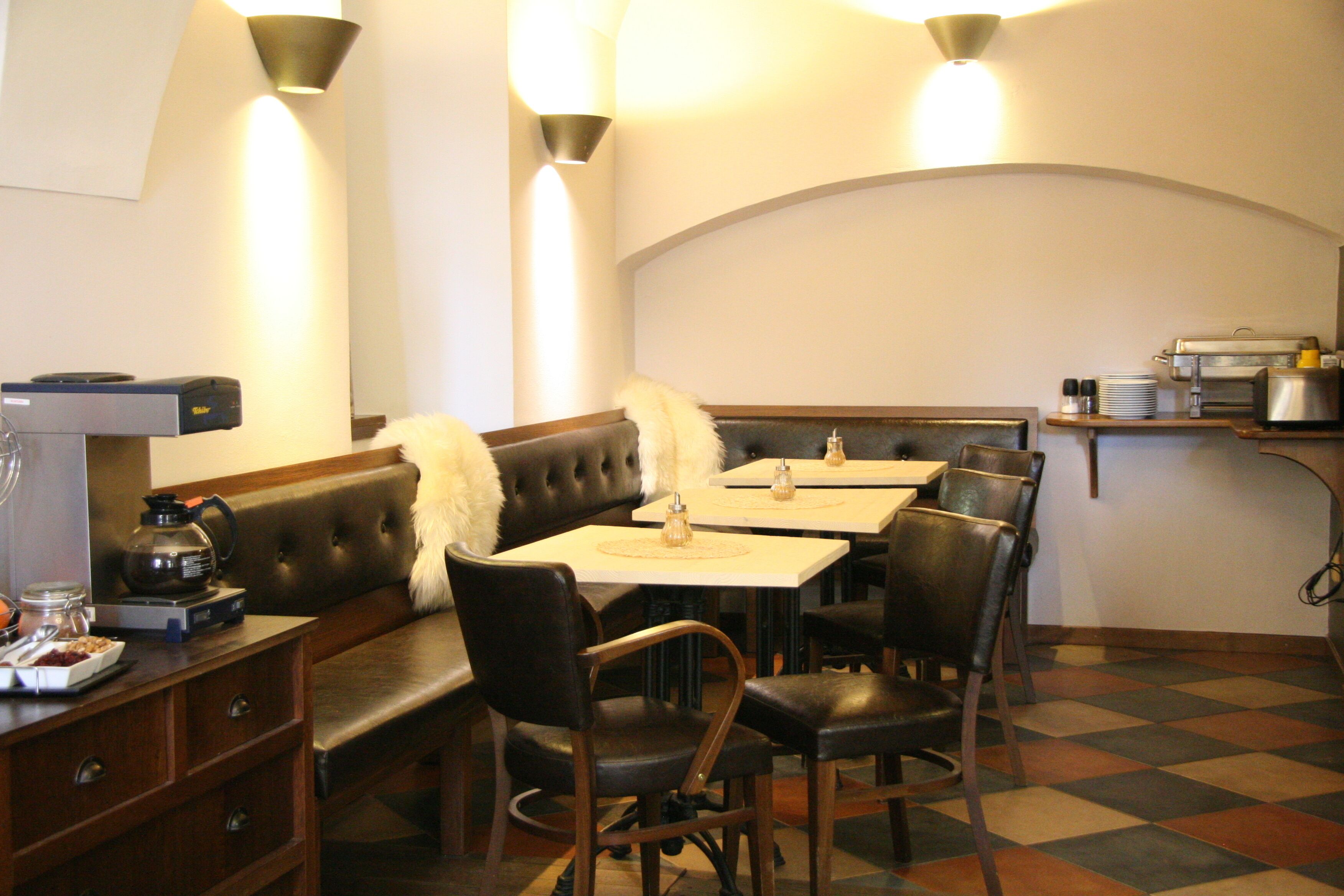 Un restaurante con zona de cabinas, una máquina de café y un mostrador de buffet.