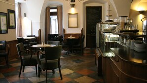 A restaurant with a checkered floor, wooden furniture, a bar area with glassware, and a chalkboard menu. - Hotel U Zvonu (Vrchlabi)