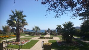 A garden pathway leading to a historic building with a view of the sea. - Lichfield House (Weymouth)