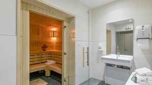 Ein modernes Badezimmer mit einer Holzaus, einem Waschbecken und einem Spiegel.