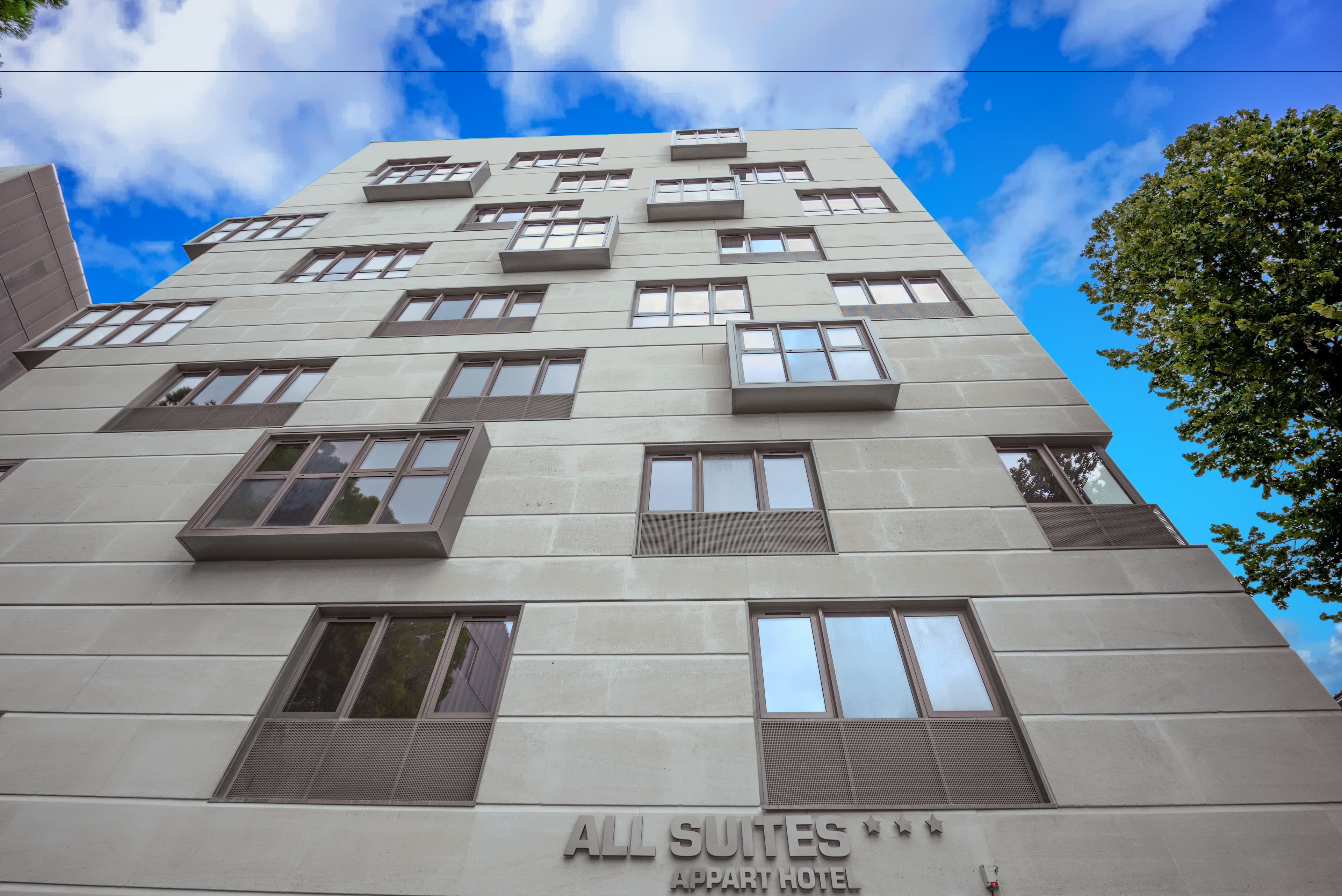 Een meerlaags gebouw met een bord waarop staat: ALL SUITES APART HOTEL.