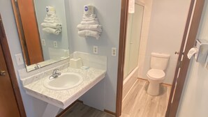 A bathroom with a marble sink, a mirror, and a toilet.