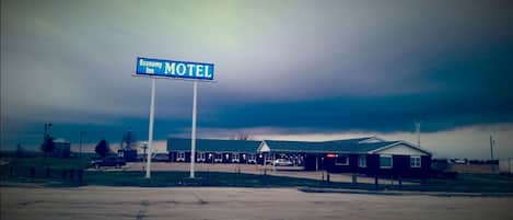 Un motel avec une enseigne indiquant « Economy Inn Motel », sous un ciel nuageux.