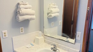 A bathroom with a white sink, a mirror, and a towel rack.