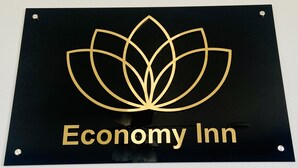 A sign with a lotus flower design and the text "Economy Inn".
