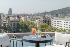 A rooftop terrace with a round table, two chairs, and a view of a cityscape. - BLESS Barcelona - Preferred Hotels & Resorts, Legend Collection (Barcelona)