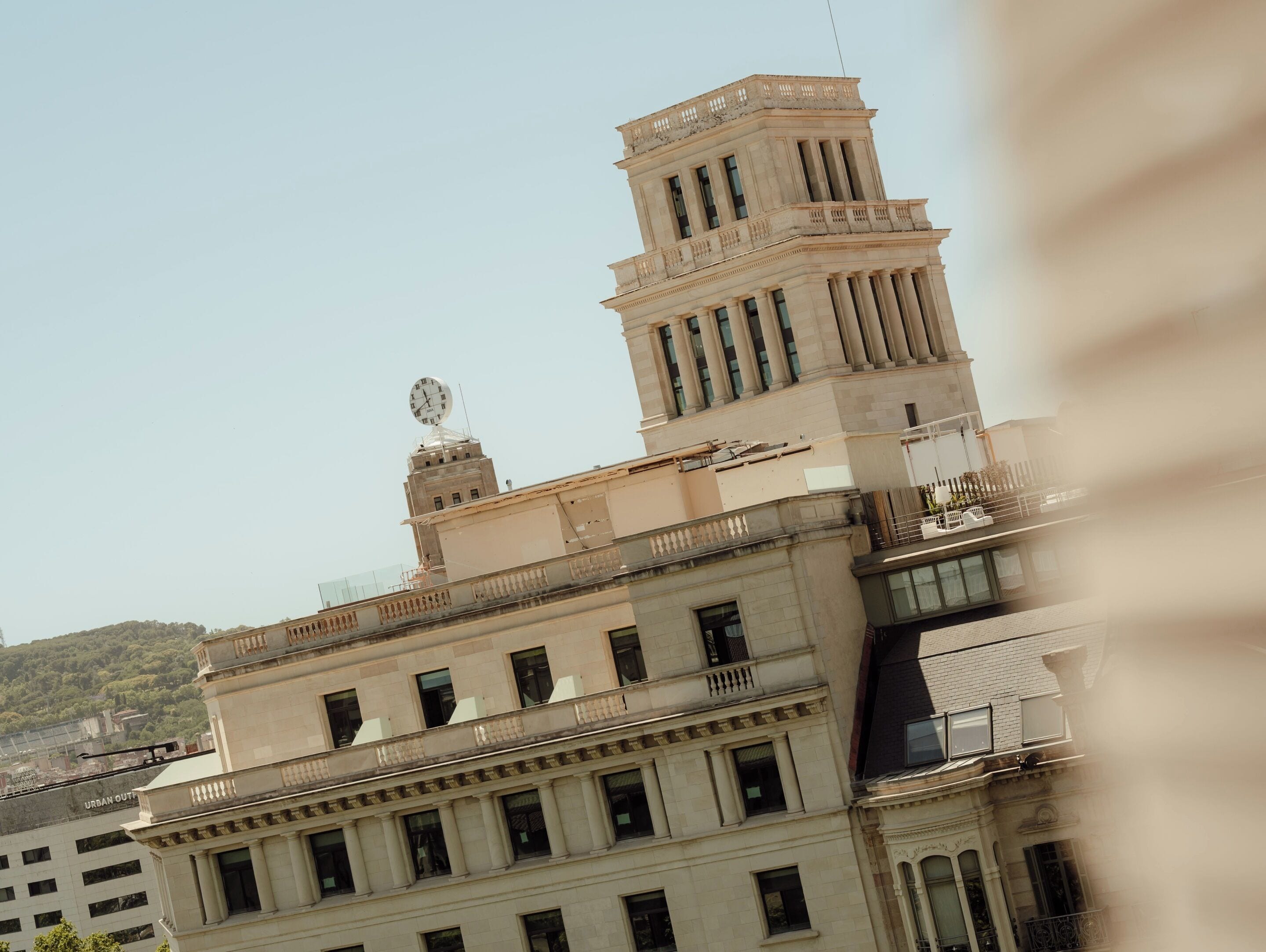 A multi-story building with classical architecture, including columns and a clock on the tower.