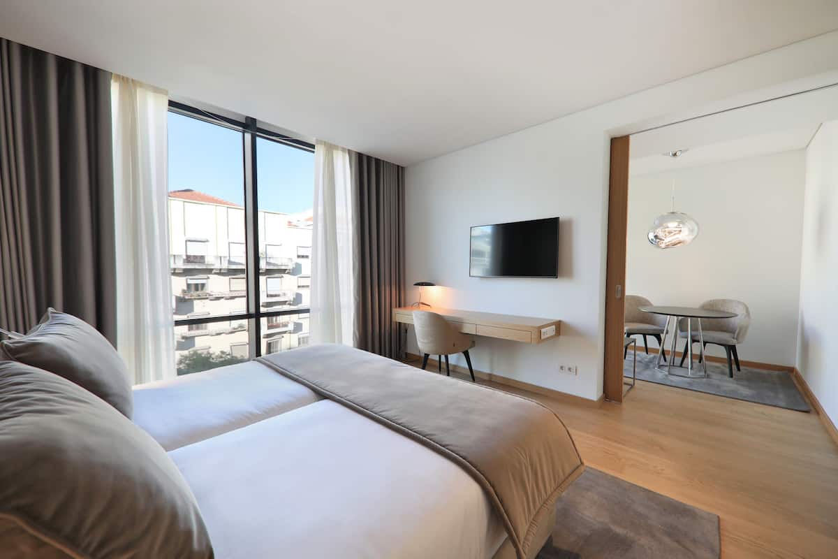 Een moderne hotelkamer met een groot bed, een bureau en een televisie.