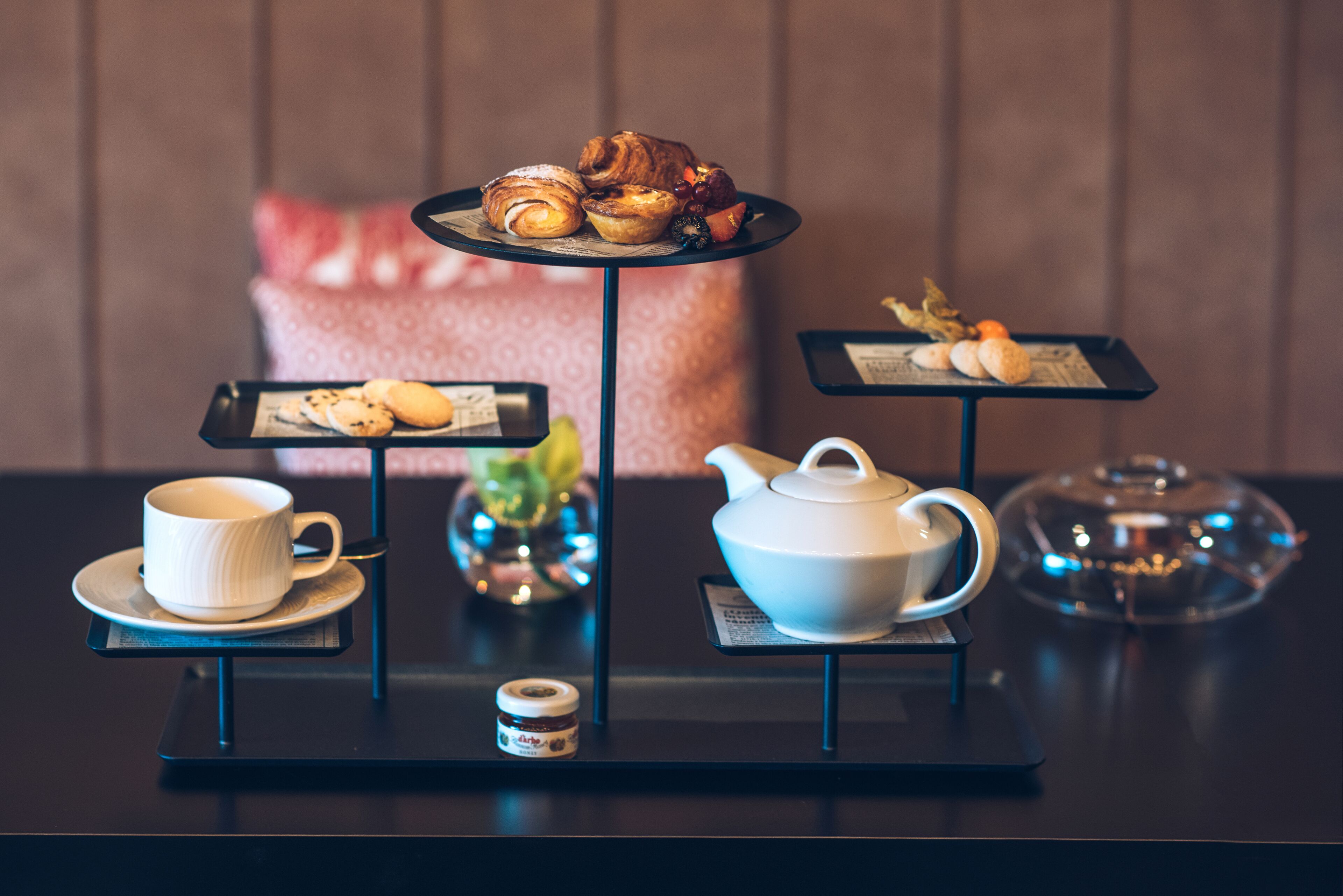 A tea service setup with pastries, a teapot, and a cup on a table.