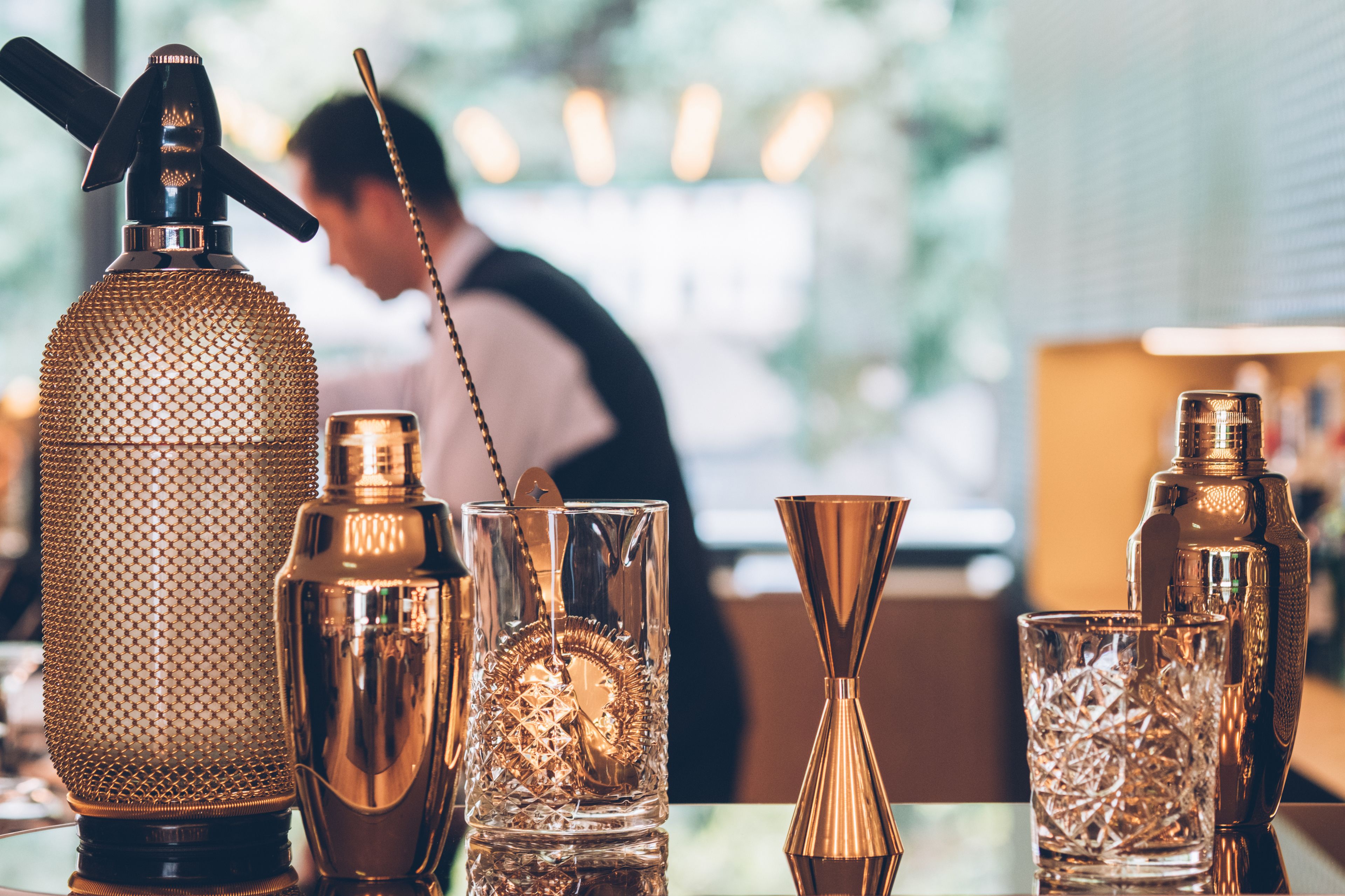 Eine Bar mit verschiedenen Cocktail-Shakern und Gläsern.