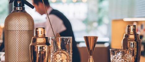 Eine Bar mit verschiedenen Cocktail-Shakern und Gläsern.