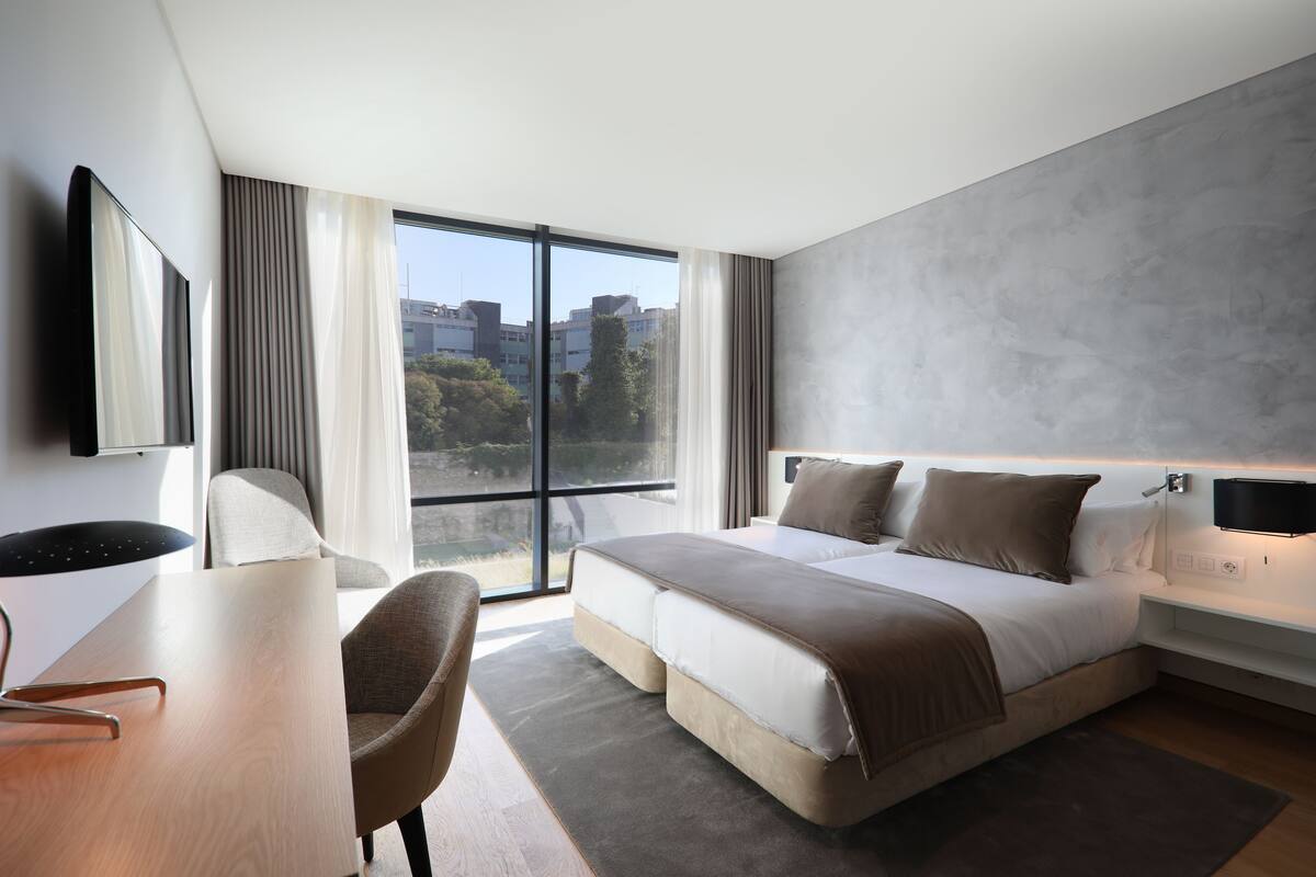 Een moderne hotelkamer met een groot bed, een bureau en een stoel.