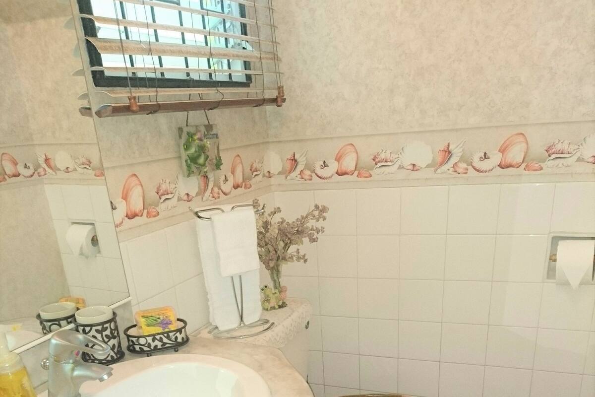 A bathroom with a sink, toilet, and decorative tiles.