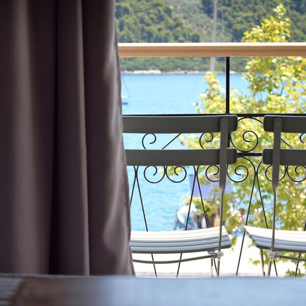 A balcony with a view of a lake and trees. - Meltemi Hotel (Skiathos)