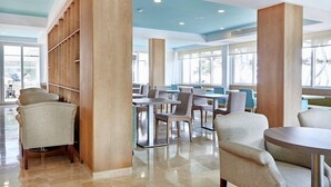 Un comedor moderno con techos altos, columnas de madera y una variedad de opciones de asientos, incluyendo sillas y mesas.