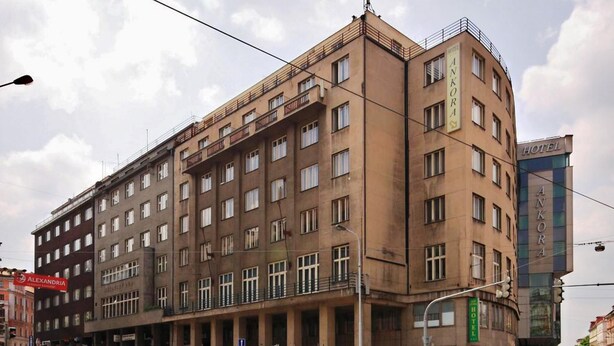 Un hotel a più piani con un design architettonico classico, con balconi ai piani superiori e un ingresso principale con insegna.