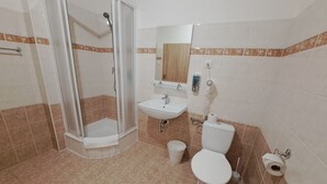 Un bagno con doccia, lavandino, WC e specchio.