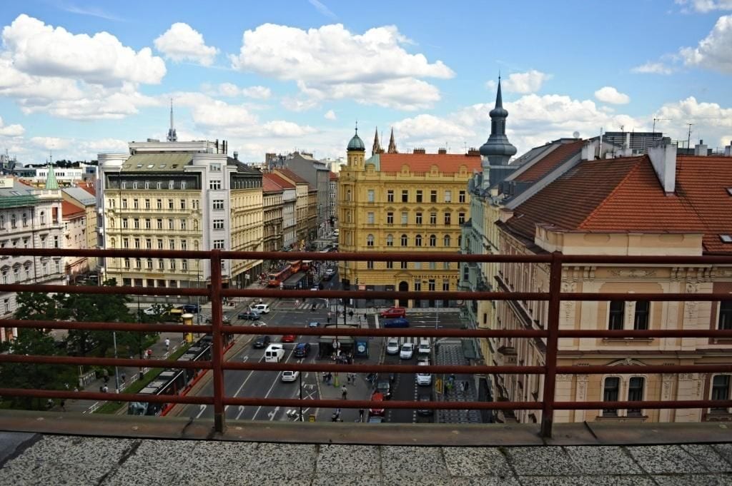 Paisagem urbana com edifícios históricos, um prédio amarelo em destaque e céu claro.