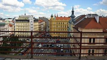 Paisagem urbana com edifícios históricos, um prédio amarelo em destaque e céu claro.