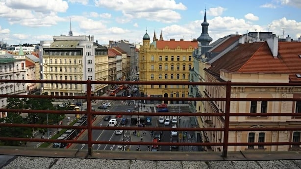 A cityscape with historic buildings, a prominent yellow building, and a clear sky.