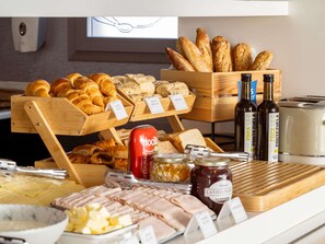 A breakfast buffet with various breads, pastries, and spreads. - Ibis Budget Madrid Vallecas (Madrid)