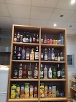 Una licorería con estantes llenos de bebidas alcohólicas y refrescos.