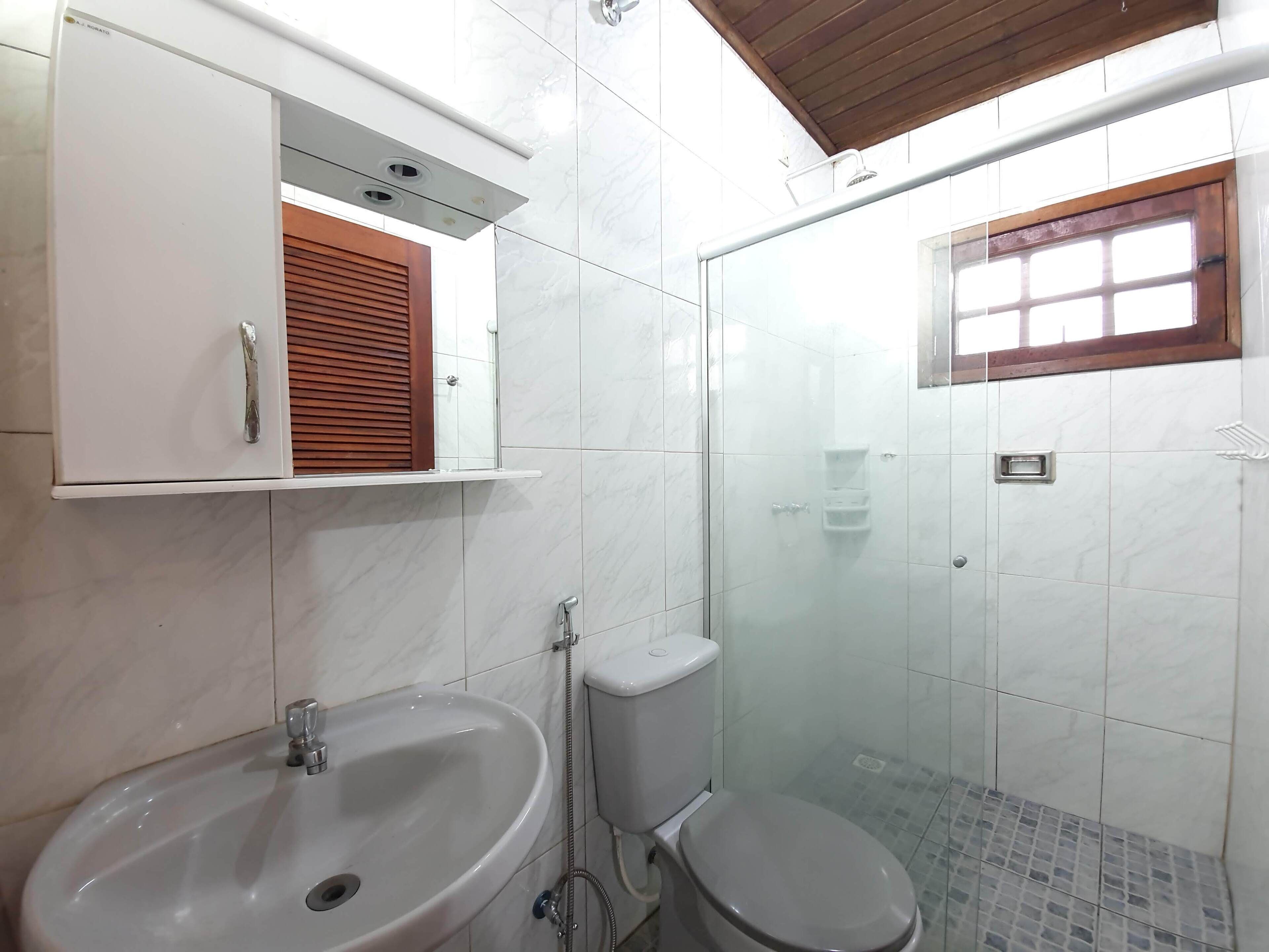 Un baño con lavamanos, inodoro y ducha.