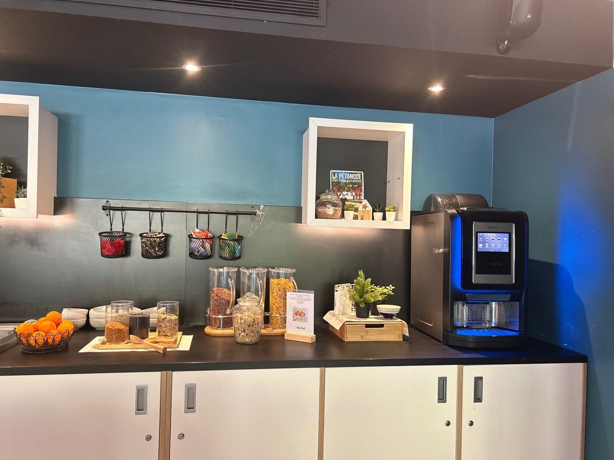 Eine Küche mit Kaffeemaschine, Gewürzgläsern und einem Küchenutensilienhalter.