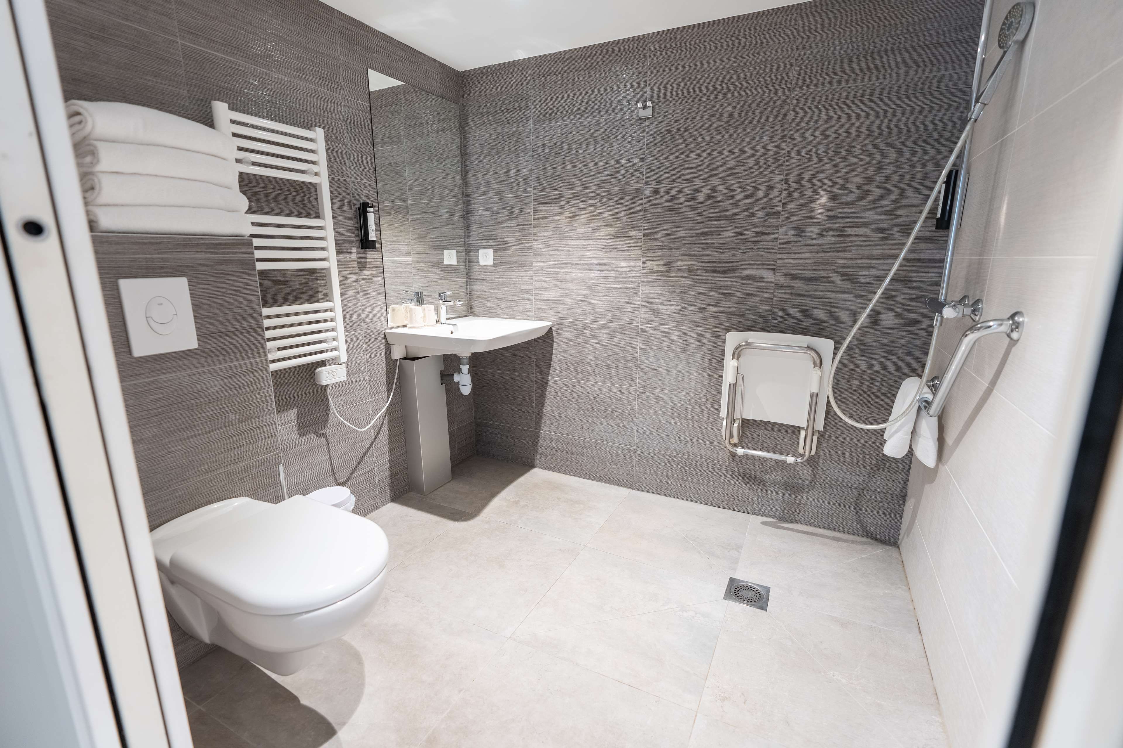 Een moderne badkamer met toilet, wastafel en douche.