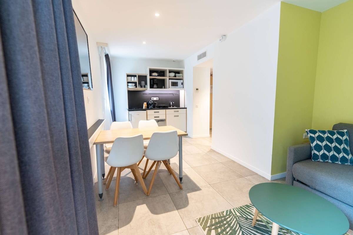 A modern apartment with a dining area, kitchen, and living space.