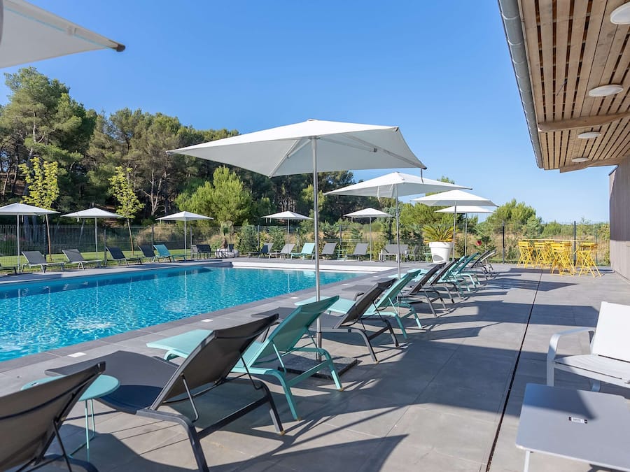 Een buitenzwembad, parasols voor strand/zwembad